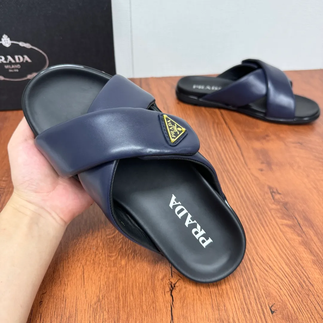 Batch 580 Prada/Prada's new men's leather cross slippers. Velcro closure can finely adjust the size. Calf leather light luxury slippers. Thick soft calf leather wraps the upper. Fat but soft rubber lazy style, soft and comfortable, excellent foot feel. Genuine leather bottom layer, cross style, with a Velcro closure buckle, easy to adjust the appropriate size, and a perfect fit for the wearing experience. The enamel gold triangle logo highlights the brand's classic features. Lightweight rubber thin sole, high foot comfort! Complete package! Size: 39-40-41-42-43-44-45 Leather shoe size Item number: 2X7132 Blue